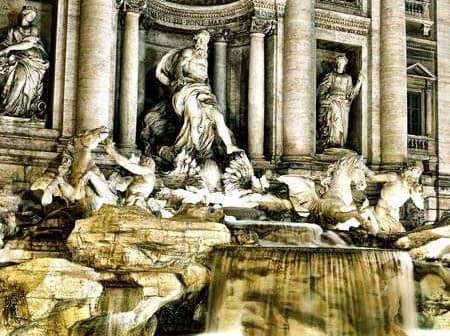 Trevi Fountain in Rome featuring sculptures and flowing water illuminated at night. - Olive Oil Times