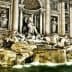 Trevi Fountain in Rome featuring sculptures and flowing water illuminated at night. - Olive Oil Times