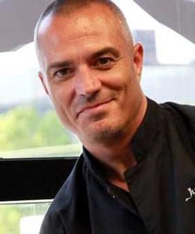 Portrait of a chef named Juan Pablo wearing a black chef's jacket and smiling at the camera. - Olive Oil Times