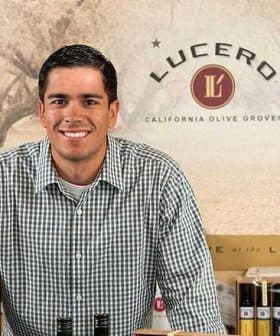 Man in a checkered shirt standing behind a counter at Lucero Olive Oil Company. - Olive Oil Times