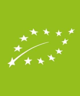 Logo representing European organic certification with stars and a curved line on a green background. - Olive Oil Times