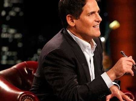 A man in a suit sitting on a leather chair, holding a pen and looking thoughtfully. - Olive Oil Times