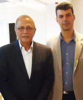 Two men standing side by side, both wearing formal attire, with one in a dark suit and the other in a light-colored blazer. - Olive Oil Times