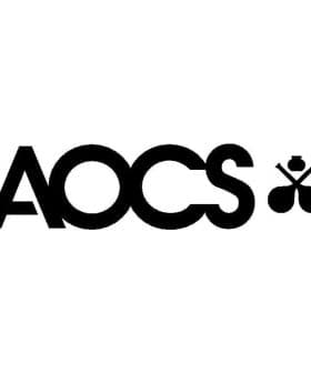 Logo of the American Oil Chemists' Society featuring the letters AOCS and a stylized olive oil drop. - Olive Oil Times