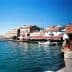 View of a coastal area in Ayvalik featuring boats and buildings along the waterfront. - Olive Oil Times