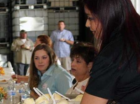 A woman serving ice cream from a tray to attendees at a gathering or event. - Olive Oil Times