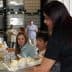 A woman serving ice cream from a tray to attendees at a gathering or event. - Olive Oil Times