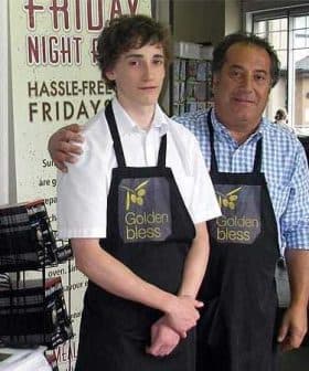 Two individuals wearing store uniforms with the logo 'Golden Bless' standing together in a retail environment. - Olive Oil Times