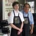 Two individuals wearing store uniforms with the logo 'Golden Bless' standing together in a retail environment. - Olive Oil Times