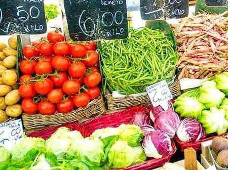 Display of fresh vegetables including tomatoes, green beans, and lettuce at a market stall. - Olive Oil Times