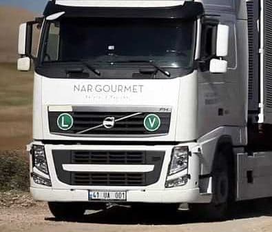 White Volvo truck with Nargourmet branding and green circular symbols on the front. - Olive Oil Times