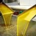 Golden olive oil flowing from metal spouts during the extraction process. - Olive Oil Times