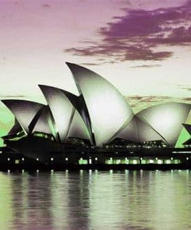 Sydney Opera House with its iconic sail-like structures reflected in the water at dusk. - Olive Oil Times