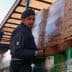 Italian police officer in uniform managing cargo on a truck with boxes and pallets. - Olive Oil Times