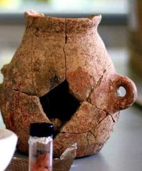 An ancient clay pot with visible cracks and a handle, displaying signs of age and wear. - Olive Oil Times