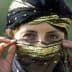Woman with a decorative black and gold headscarf partially covering her face, revealing her eyes. - Olive Oil Times