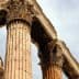 Close-up view of ancient Greek columns featuring Corinthian capitals and weathered stone. - Olive Oil Times