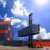 Red forklift lifting a blue shipping container at a cargo yard with stacked containers in the background. - Olive Oil Times