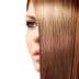 Close-up view of a woman's face partially obscured by smooth, straight brown hair. - Olive Oil Times