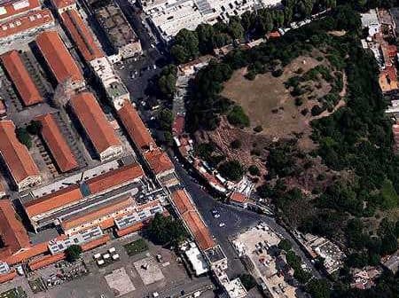 Aerial view showing a mix of buildings and a green park area in an urban setting. - Olive Oil Times