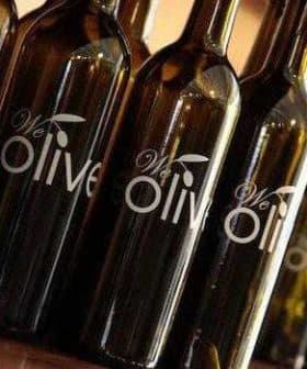 Several dark glass bottles with a label that reads 'We Olive' displayed in a row. - Olive Oil Times
