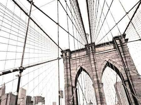 View of the Brooklyn Bridge's structure with cables and city skyline in the background. - Olive Oil Times