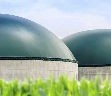 Two large green storage tanks with a smooth dome shape and concrete bases. - Olive Oil Times