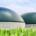 Two large green storage tanks with a smooth dome shape and concrete bases. - Olive Oil Times