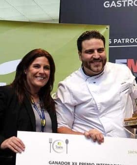 Chef holding an award while posing with a woman at a gastronomy event. - Olive Oil Times