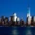 Night view of New York City skyline featuring One World Trade Center and surrounding buildings. - Olive Oil Times
