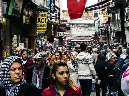 A bustling street in Turkey filled with people walking and shops lining the sides. - Olive Oil Times