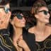 Three women smiling and wearing sunglasses at an event, showcasing various styles of eyewear. - Olive Oil Times
