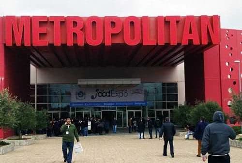 Entrance of the Metropolitan Exhibition Center with a large red sign above the doors. - Olive Oil Times