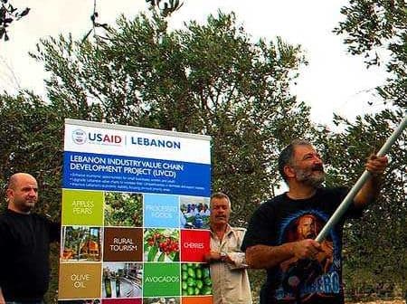 Three men participating in the USAID Lebanon Industry Value Chain Development Project with a banner in the background. - Olive Oil Times