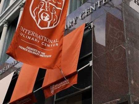 Exterior view of the International Culinary Center with banners displaying its name and founding details. - Olive Oil Times