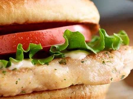 Grilled chicken sandwich featuring lettuce, tomato, and mayonnaise on a bun. - Olive Oil Times