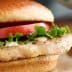 Grilled chicken sandwich featuring lettuce, tomato, and mayonnaise on a bun. - Olive Oil Times
