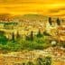 View of the city of Fez, Morocco, with buildings and trees under a yellow sunset sky. - Olive Oil Times
