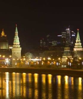 Night view of the Moscow Kremlin with illuminated towers and buildings along the river. - Olive Oil Times