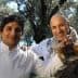 Two chefs posing together, one holding a bottle of yuzu olive oil in an outdoor setting. - Olive Oil Times