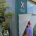 Person using an ATM at the Bank of Chania with a visible bank logo. - Olive Oil Times