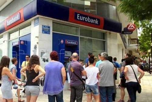 Customers waiting in line outside a Eurobank branch in a city setting. - Olive Oil Times