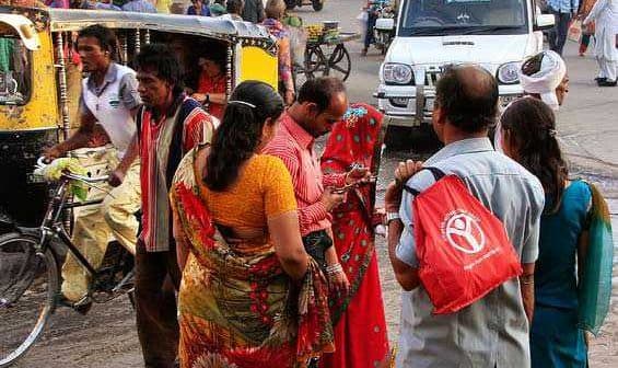 People interacting on a busy street in India with various vehicles and pedestrians present. - Olive Oil Times