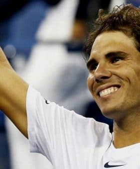 Tennis player Rafael Nadal smiling and raising his hand in celebration at a match. - Olive Oil Times