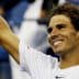 Tennis player Rafael Nadal smiling and raising his hand in celebration at a match. - Olive Oil Times