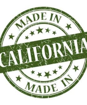 Green circular stamp with the text 'Made in California' and stars in a distressed style. - Olive Oil Times
