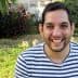 Man with short dark hair wearing a striped shirt, smiling at the camera outdoors. - Olive Oil Times