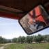 Reflection of a tractor's rear light in the side mirror while parked in an olive grove. - Olive Oil Times