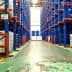 Interior view of a warehouse featuring rows of blue storage barrels on shelves. - Olive Oil Times