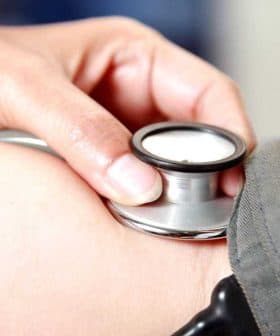 A healthcare professional using a stethoscope on a patient's arm during a medical examination. - Olive Oil Times